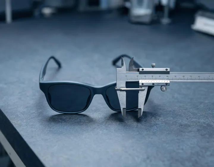Reading sunglasses on an optical bench with size callouts, illustration only